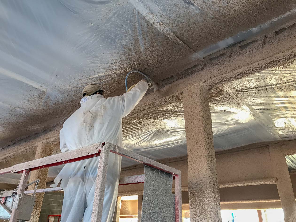 Payless Employee spray installing Fireproofing substrate